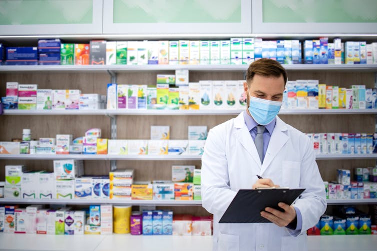 A man serving at a pharmacy.