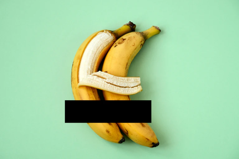 Two bananas cuddling one another