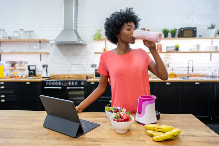 A woman drinking a protein shake.