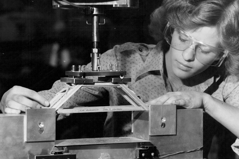 Black and white photo of a woman with protective eyewear with a model bridge.