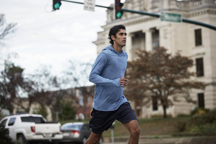 A young man runs past a county courthouse.