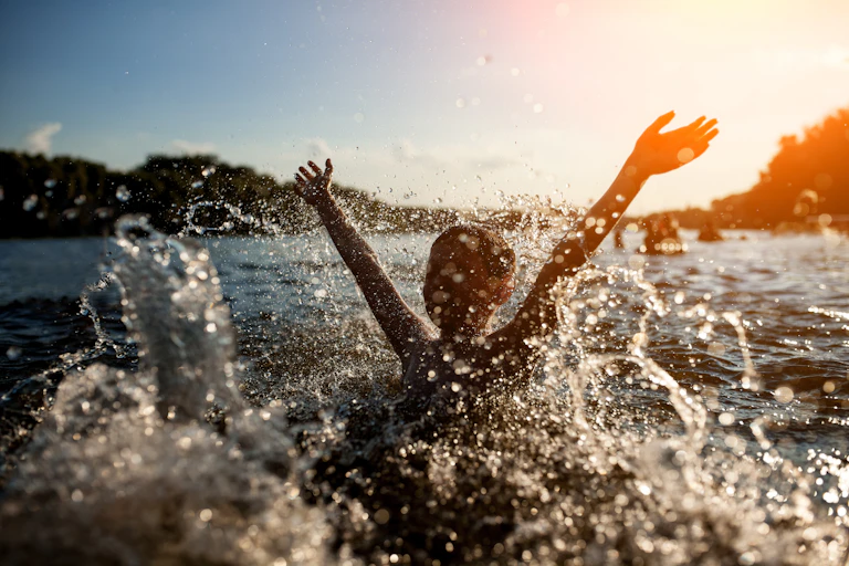 Young child playing in water and making a splash