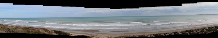 Panorama of a beach with lots of waves.