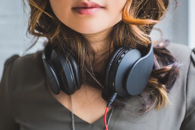 Une adolescente porte son casque autour du cou