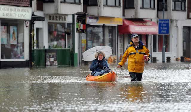 Woman in canoe on flooded street