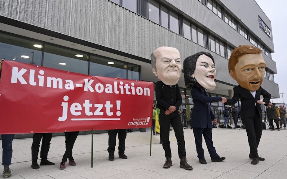 Personnes portant des masques des trois principaux dirigeants de la future coalition allemande