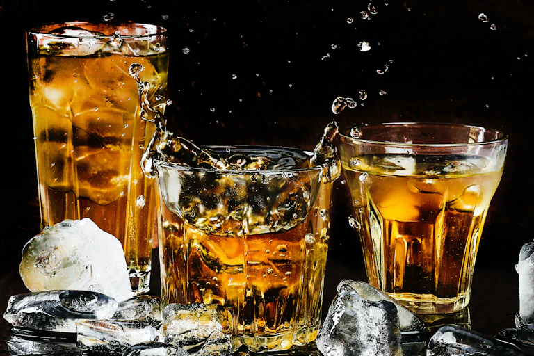 Trois verre d'alcool ambré s'entrechoquent