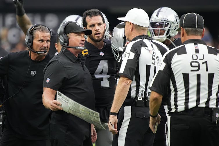 Former Las Vegas Raiders head coach Jon Gruden speaks with officials