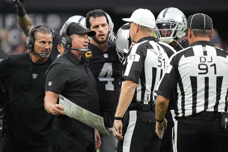 Former Las Vegas Raiders head coach Jon Gruden speaks with officials