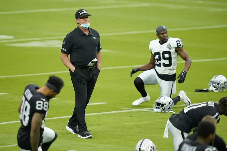 Las Vegas Raiders former head coach Jon Gruden walks across the field during an NFL football training camp practice