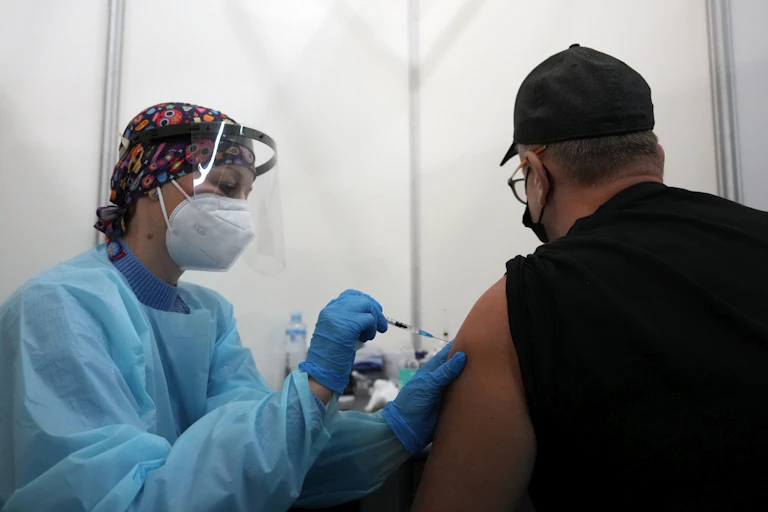 Health worker administering someone a COVID-19 vaccine