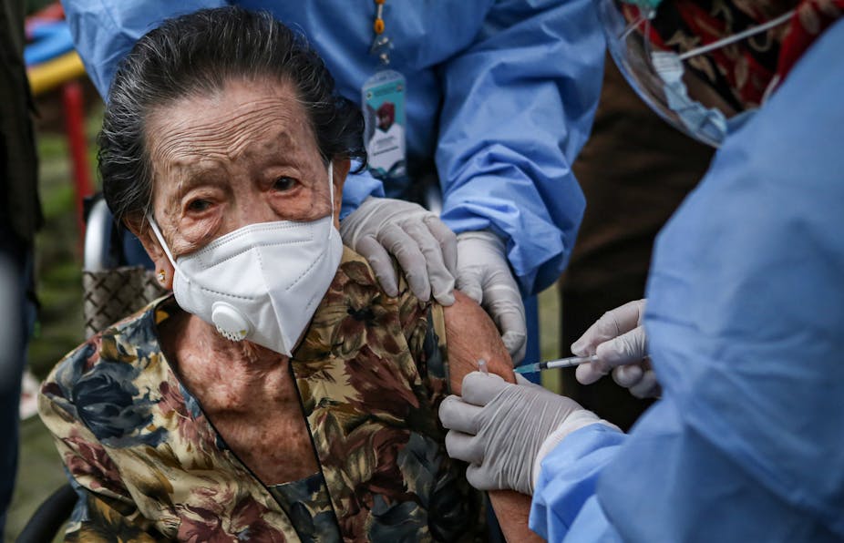 Seorang warga lansia menerima suntikan vaksin