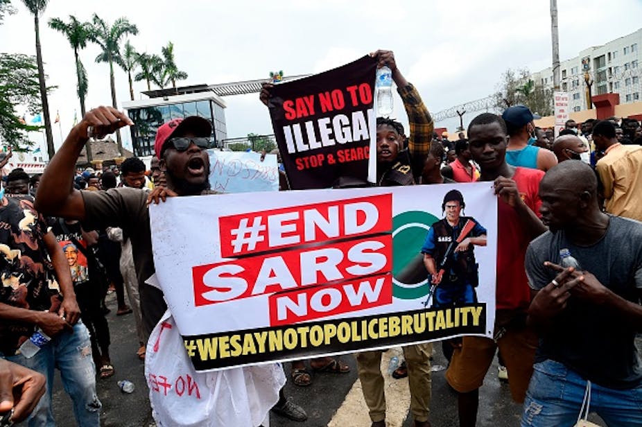 People in the street holding banner with the inscription #EndSARS now