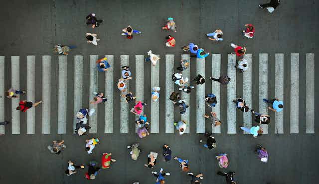 People walking over a zebra crossing, from above
