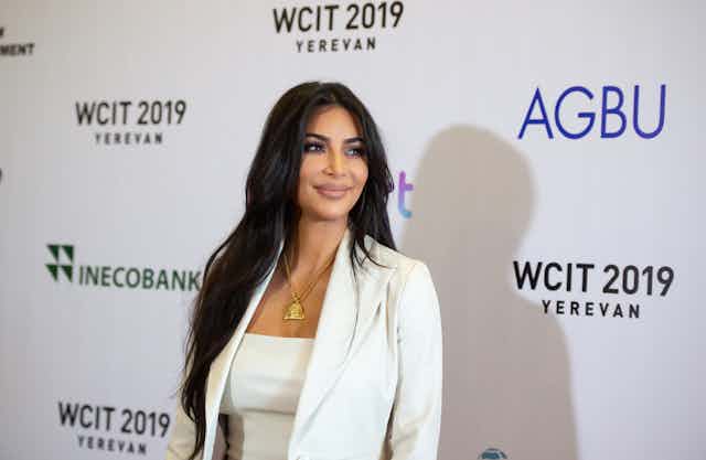 Kim Kardashian debout devant une affiche