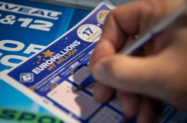 Close-up photo of someone's hand completing a Euromillions ticket