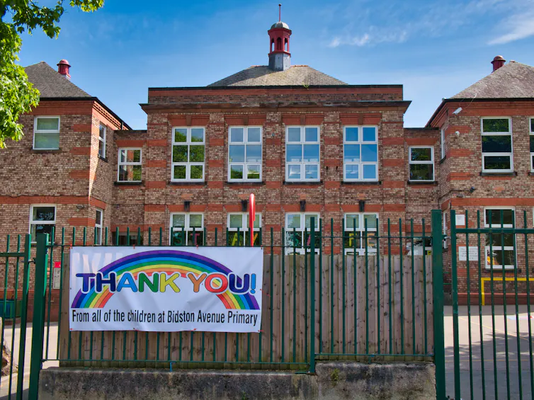 A primary school with a large THANK YOU NHS banner on the fence.