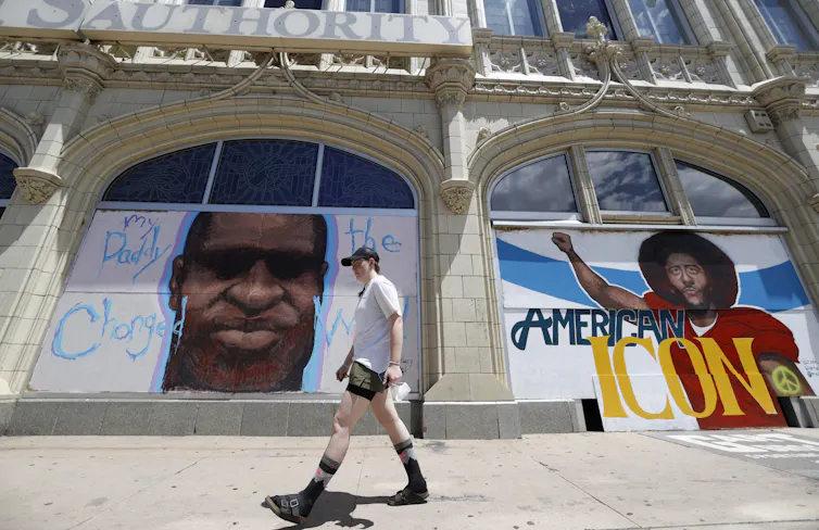 A mural to honour George Floyd and former NFL quarterback Colin Kaepernick are plastered on a building.