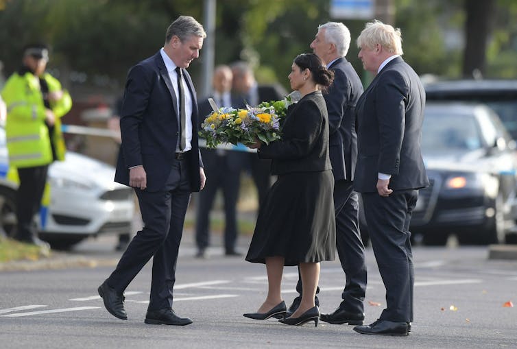 Keir Starmer, Priti Patel, Lynsey Hoyle e Boris Johnson se vestiram de preto no local do assassinato de David Amess.  Patel está segurando uma coroa de flores.
