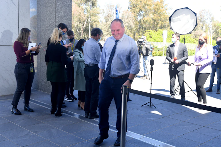 man walks away from reporters