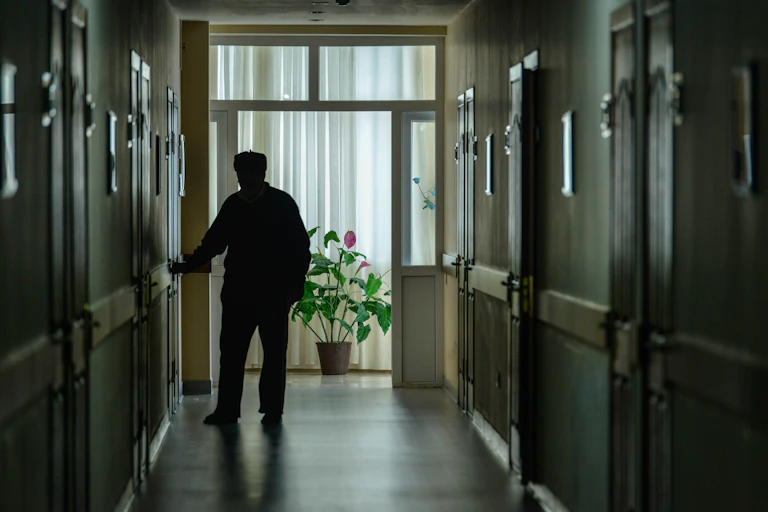 man in pjs in corridor