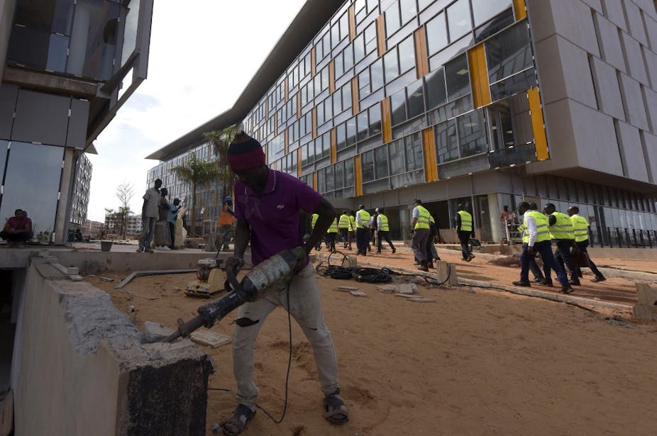 Ouvrier travaillant le ciment dans un quartier en construction au Sénégal.