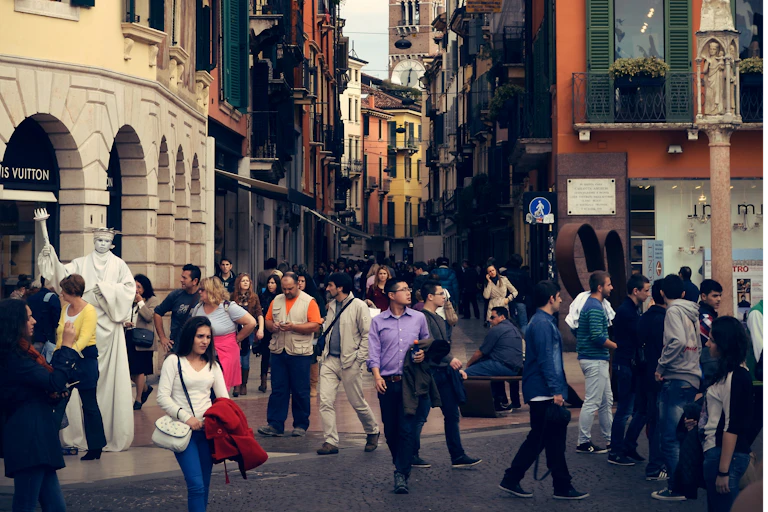 Pedestrians walk in different directions in an old city street