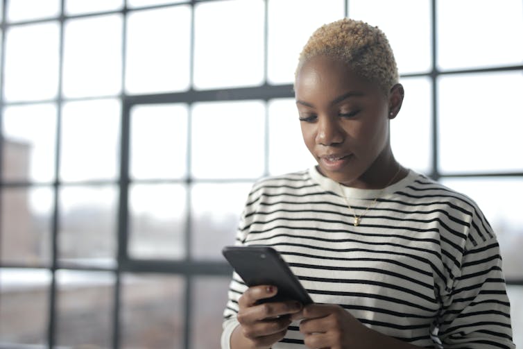 A ladies in a striped shirt would seem down at her business phone.