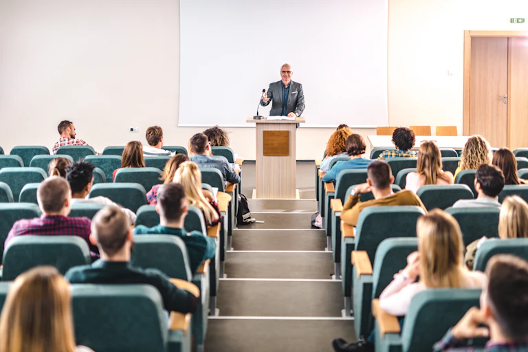 A college professor lectures to a room of students.