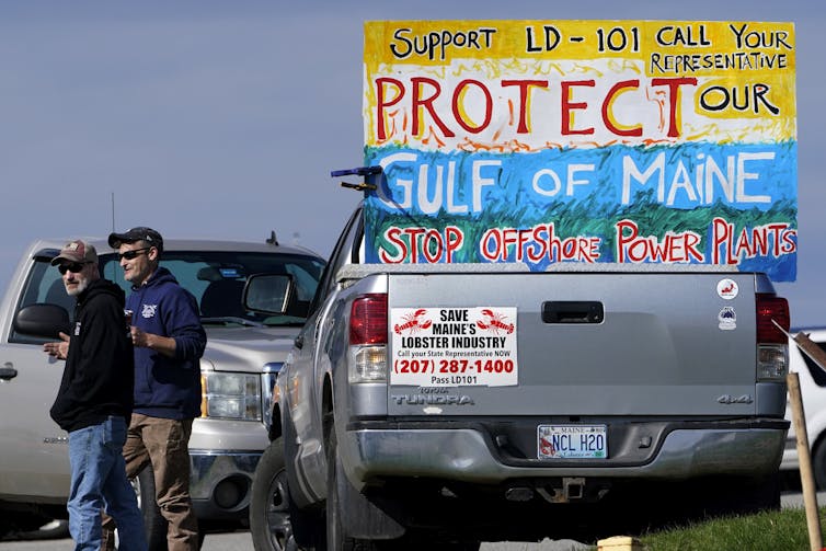 Pickup truck carrying anti-wind power signs.