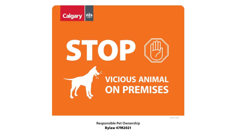 Orange sign with a white silhouette of a dog, reading 'vicious animal on premisies'