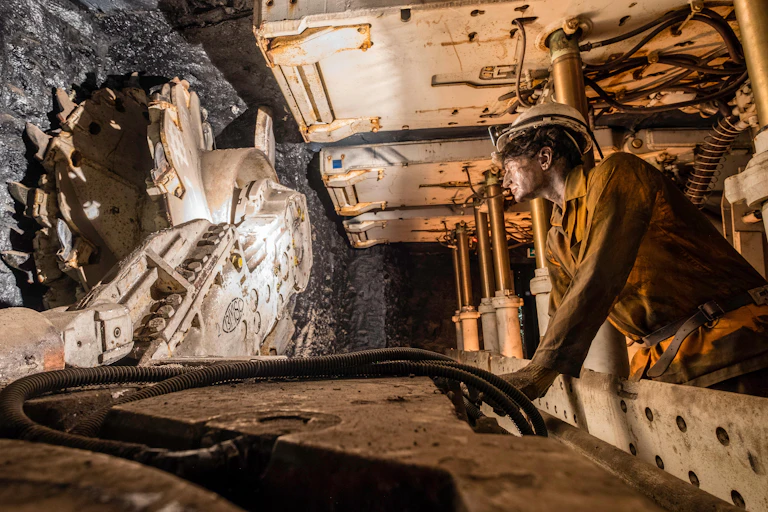 A museum exhibition depicting a worker operating a large coal drill.