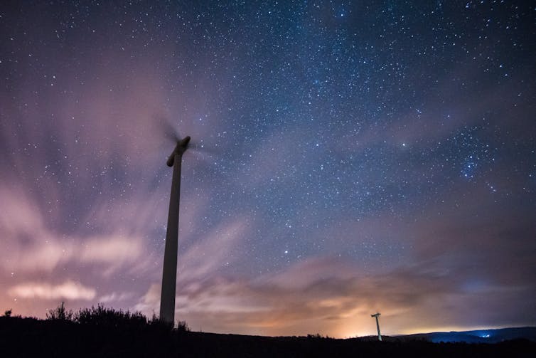 A spinning wind turbine at night.