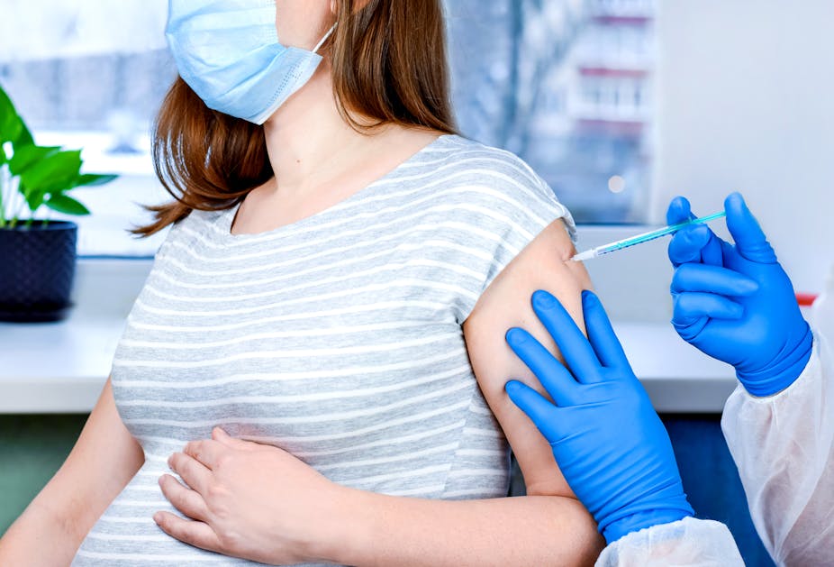 A pregnant woman being vaccinated for COVID