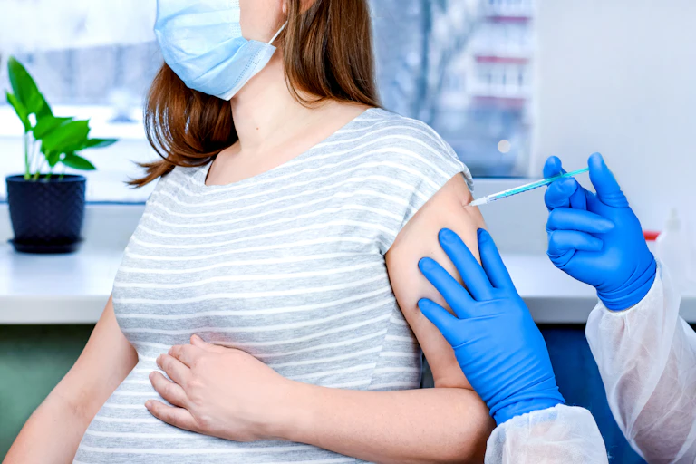 A pregnant woman being vaccinated for COVID