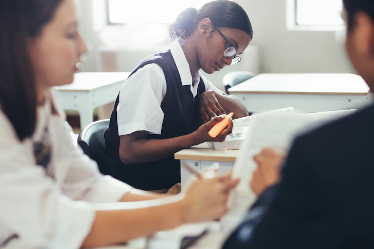 High school students in their school uniform seated in a classroom.