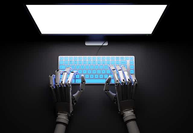 Robotic hands at a computer.