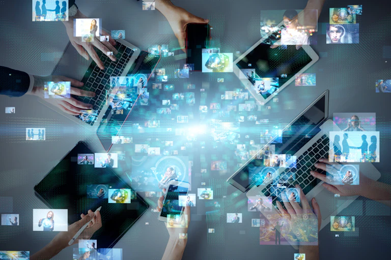 Birds eye view of a table with laptops and floating images