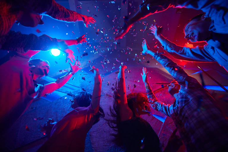 People dancing in club with hands in air
