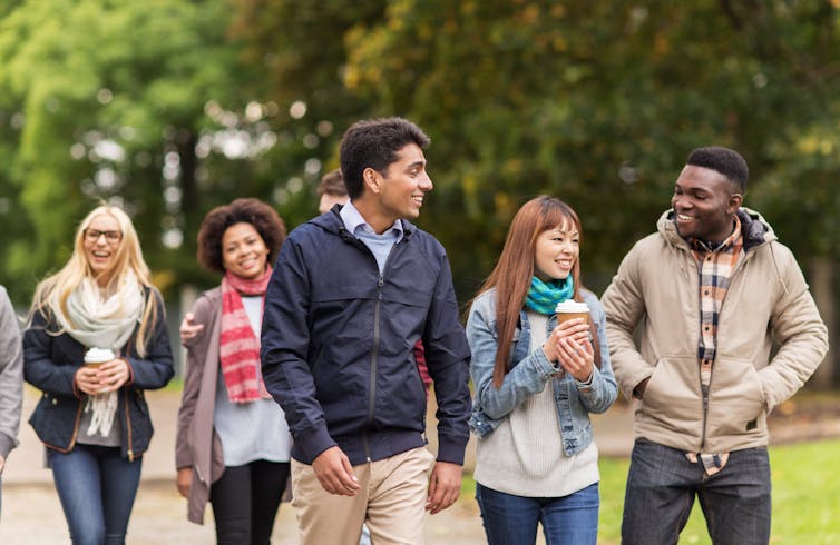 Group of diverse university students walking.