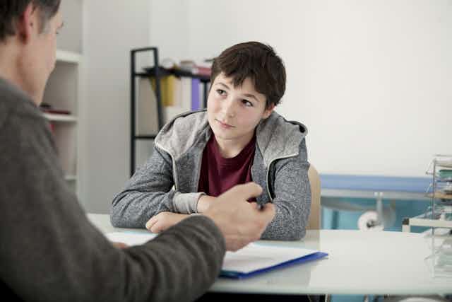 Child looks at his psychologist, who is talking.
