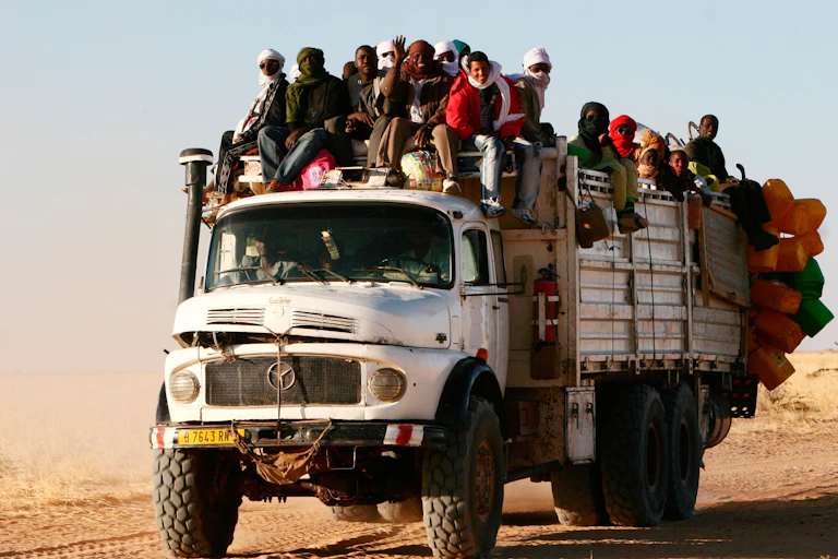 Old truck loaded with people and supplies.