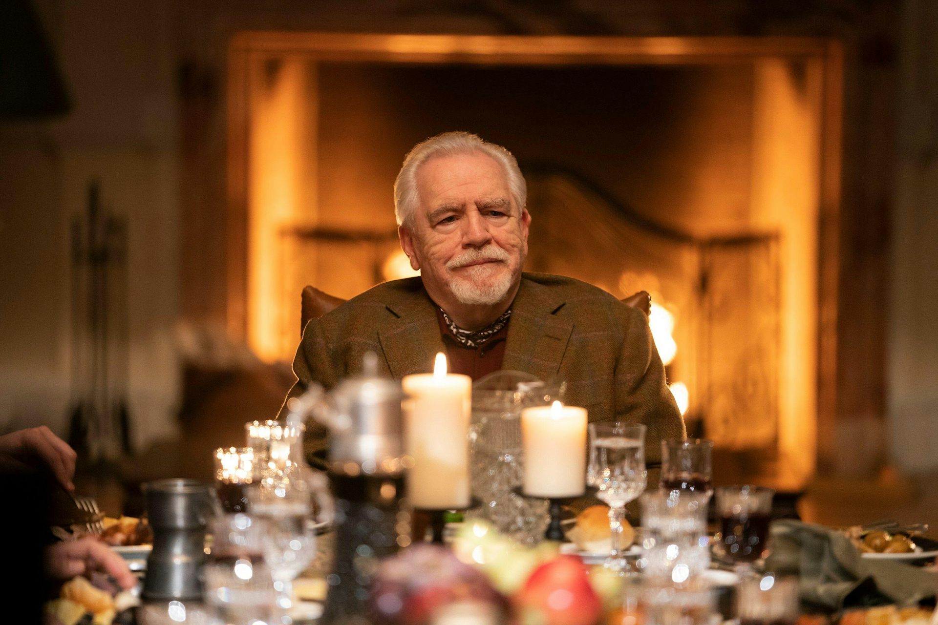 Man sits at top of table with candles