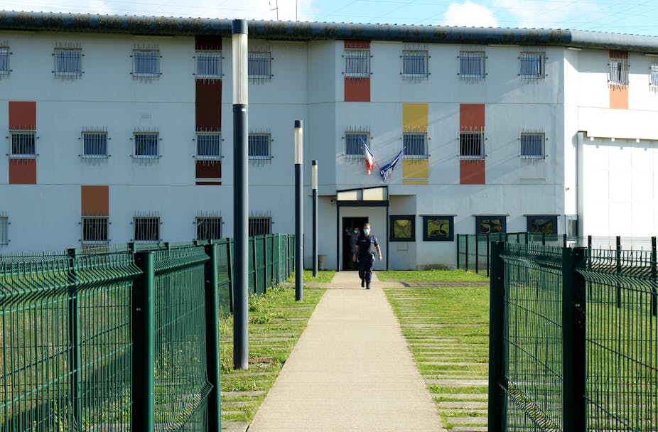 Un agent pénitentiaire se tient à l'entrée du centre pénitentiaire d'Alencon, à Condé-sur-Sarthe, dans le nord-ouest de la France, le 5 octobre 2021, après la reddition d'un détenu qui avait pris en otage des gardiens de prison.