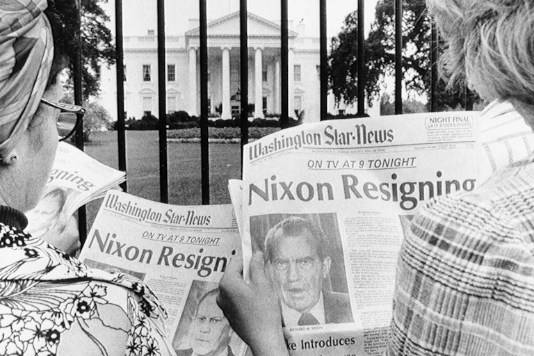 Tourists in front of the White House read headlines saying President Nixon will resign..