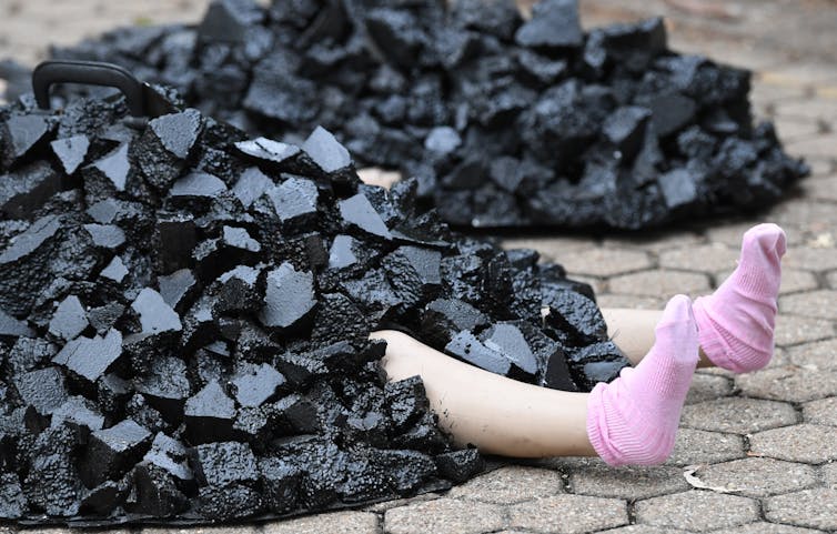feet sticking out from fake pile of coal