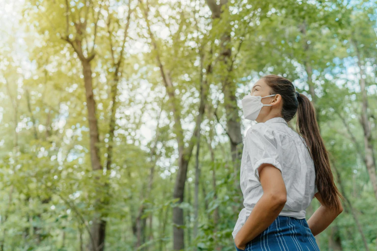 Girl wearing mask in a forest