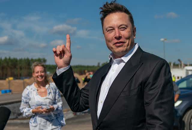 Image of Elon Musk pointing up towards the sky.