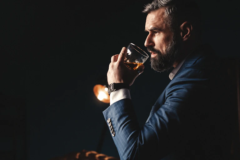 A man drinking a glass of brandy