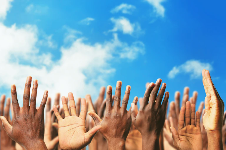 Many hands reaching up towards the sky